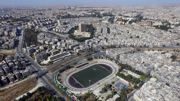 A general view taken with a drone shows buses parked outside the municipal stadium in the government-controlled area of Aleppo, as they wait to evacuate people wishing to leave besieged eastern Aleppo, Syria October 20, 2016. - Sputnik International