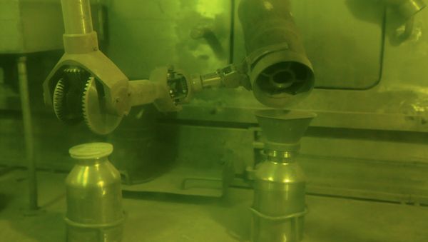 Operator putting plutonium dioxide powder in a container for storage and processing using handler. - Sputnik International