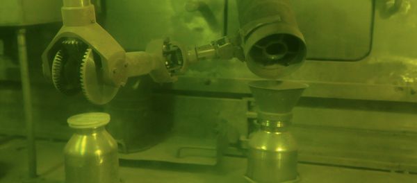 Operator putting plutonium dioxide powder in a container for storage and processing using handler. - Sputnik International