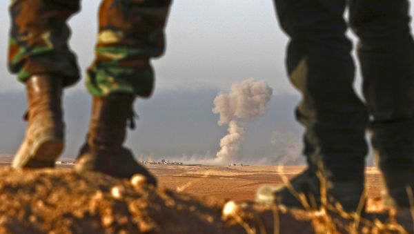 Iraqi Kurdish Peshmerga fighters stand in an area near the town of Bashiqa, some 25 kilometres north east of Mosul - Sputnik International