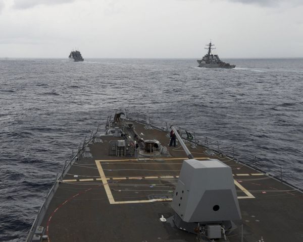 the guided missile destroyer USS Decatur, right, pulling into position behind the Military Sealift Command USNS Matthew Perry, during a replenishment-at-sea, seen from the bridge of the guided-missile destroyer USS Spruance, in the South China Sea. - Sputnik International