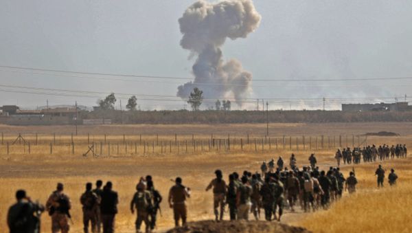 Smoke billows from an area near the Iraqi town of Nawaran, some 10km north east of Mosul, as Iraqi Kurdish Peshmerga fighters march down a dirt road on October 20, 2016, during the ongoing operation to retake the city from the Islamic State (IS) group - Sputnik International