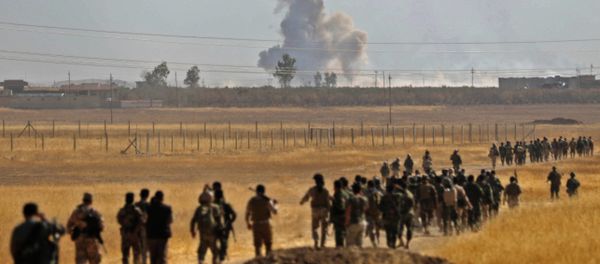 Smoke billows from an area near the Iraqi town of Nawaran, some 10km north east of Mosul, as Iraqi Kurdish Peshmerga fighters march down a dirt road on October 20, 2016, during the ongoing operation to retake the city from the Islamic State (IS) group Smoke billows from an area near the Iraqi town of Nawaran, some 10km north east of Mosul, as Iraqi Kurdish Peshmerga fighters march down a dirt road on October 20, 2016, during the ongoing operation to retake the city from the Islamic State (IS) group - Sputnik International