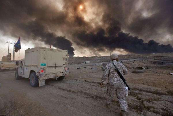 Iraqi army are seen in Qayyara, Iraq, October 22, 2016. The fumes in the background are from oil wells that were set ablaze by Islamic State militants - Sputnik International