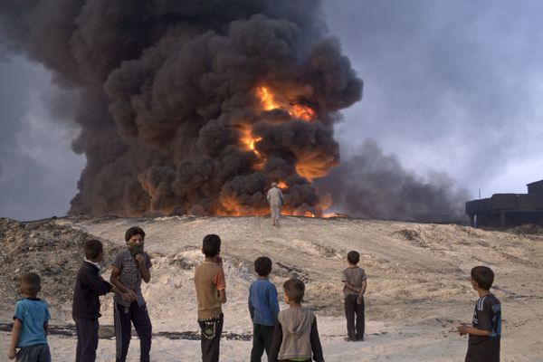 FILE -- In this Sunday, Oct. 23, 2016 file photo, people watch a burning oil well in Qayyarah, about 31 miles (50 km) south of Mosul, Iraq - Sputnik International