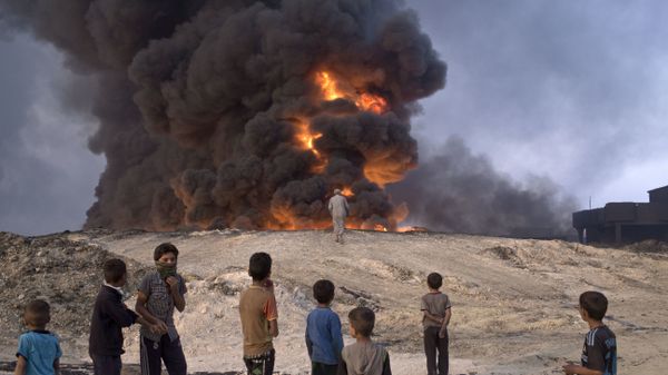 FILE -- In this Sunday, Oct. 23, 2016 file photo, people watch a burning oil well in Qayyarah, about 31 miles (50 km) south of Mosul, Iraq - Sputnik International