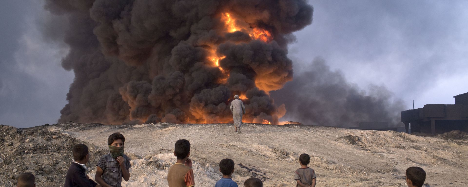 FILE -- In this Sunday, Oct. 23, 2016 file photo, people watch a burning oil well in Qayyarah, about 31 miles (50 km) south of Mosul, Iraq FILE -- In this Sunday, Oct. 23, 2016 file photo, people watch a burning oil well in Qayyarah, about 31 miles (50 km) south of Mosul, Iraq - Sputnik International, 1920, 24.10.2023