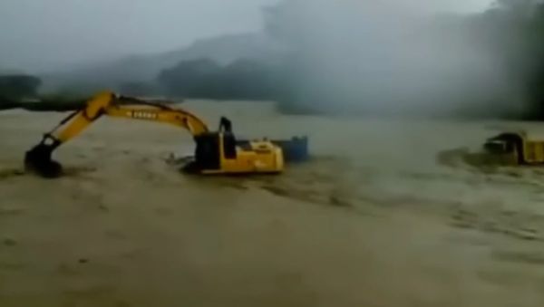 Extreme Salvation of Truck Drivers by Excavator - Sputnik International