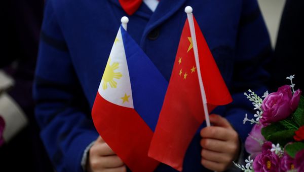 Children hold plastic flowers, national flags of China and the Philippines before President of the Philippines Rodrigo Duterte and China's President Xi Jinping attend a welcoming ceremony at the Great Hall of the People in Beijing, China, October 20, 2016 - Sputnik International