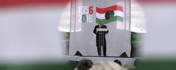 Hungarian Prime Minister Viktor Orban delivers his address as pictured through a hole on the national flag during the state commemoration ceremony of the 1956 Hungarian revolution and freedom fight against communism and Soviet rule in front of the Parliament building in downtown Budapest, Hungary, Sunday, Oct. 23, 2016 - Sputnik International