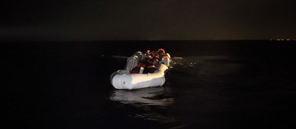 Refugees and migrants wait to be rescued from their sinking rubber boat some eight nautical miles off Libya's Mediterranean coastline on October 12, 2016 - Sputnik International