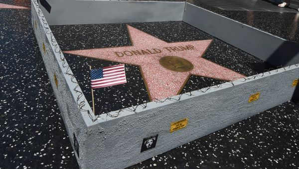 The Hollywood Walk of Fame Star of Republican presidential candidate Donald Trump is surrounded by a miniture barbed-wire wall placed there by Californian street artist Plastic Jesus in Hollywood, California on July 20, 2016 - Sputnik International
