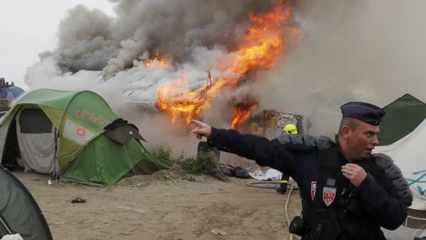 French CRS riot police secure the area near burning makeshift shelters and tents in the Jungle on the third day of the evacuation of migrants and their transfer to reception centers in France, as part of the dismantlement of the camp in Calais, France, October 26, 2016. - Sputnik International