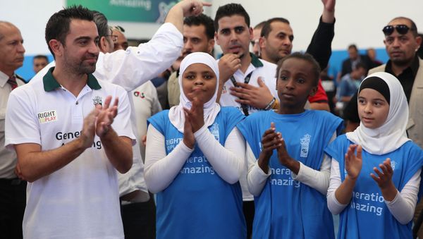 Former Barcelona football player Xavi Hernandez (L), who currently plays for Al-Sadd in the Qatar Stars League, claps during a football training as he visits the al-Baqaa Palestinian refugee camp near Amman on September 29, 2016. - Sputnik International