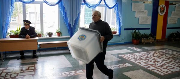 A member of a local electoral commission carries a ballot box at a polling station ahead of the presidential election in Chisinau, Moldova, October 29, 2016. - Sputnik International