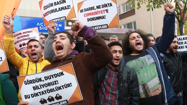 Participants hold placards reading 'Free press can't be silenced' (C) and 'Do not touch Cumhuriyet' (R) outside the headquarters of Turkish newspaper Cumhuriyet in Ankara on October 31, 2016, during a protest against the detention of the newspaper's editor-in-chief and a dozen journalists and executives - Sputnik International