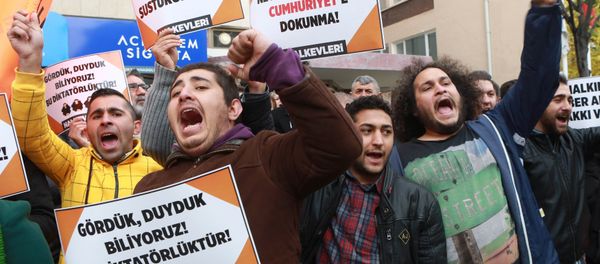 Participants hold placards reading 'Free press can't be silenced' (C) and 'Do not touch Cumhuriyet' (R) outside the headquarters of Turkish newspaper Cumhuriyet in Ankara on October 31, 2016, during a protest against the detention of the newspaper's editor-in-chief and a dozen journalists and executives Participants hold placards reading 'Free press can't be silenced' (C) and 'Do not touch Cumhuriyet' (R) outside the headquarters of Turkish newspaper Cumhuriyet in Ankara on October 31, 2016, during a protest against the detention of the newspaper's editor-in-chief and a dozen journalists and executives - Sputnik International
