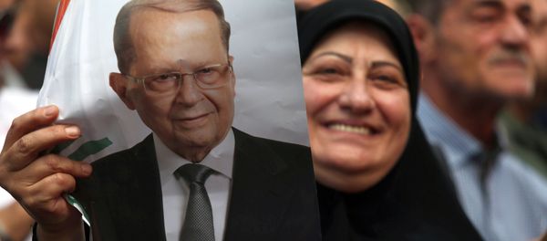 A woman carries a picture of newly elected Lebanese President Michel Aoun in the Haret Hreik area, southern suburbs of Beirut, Lebanon October 31, 2016 - Sputnik International