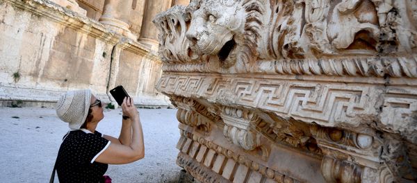 A visitor takes pictures of a bas-relief with heads of lions from the roof of the Temple of Jupiter in a temple complex of Baalbek, Lebanon - Sputnik International