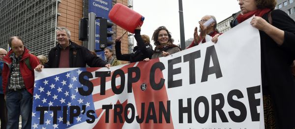 People hold a banner reading Stop EU-Canada Comprehensive Economic and Trade Agreement (CETA), Transatlantic Trade and Investment Partnership (TTIP)'s trojan horse during a protest against the CETA at European Union Commission headquarters in Brussels on October 27, 2016 People hold a banner reading Stop EU-Canada Comprehensive Economic and Trade Agreement (CETA), Transatlantic Trade and Investment Partnership (TTIP)'s trojan horse during a protest against the CETA at European Union Commission headquarters in Brussels on October 27, 2016 - Sputnik International