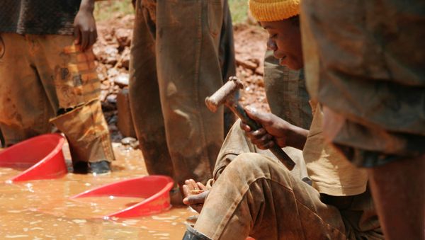 An unidentified miner sifts through sand and smashed rocks looking for gold at the town of Mongbwalu, Congo (File) - Sputnik International