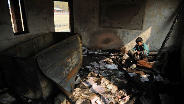 A Kashmiri student looks at damaged property at a partially burnt government high school in Goripora, on the outskirts of Srinagar on November 2, 2016 A Kashmiri student looks at damaged property at a partially burnt government high school in Goripora, on the outskirts of Srinagar on November 2, 2016 - Sputnik International
