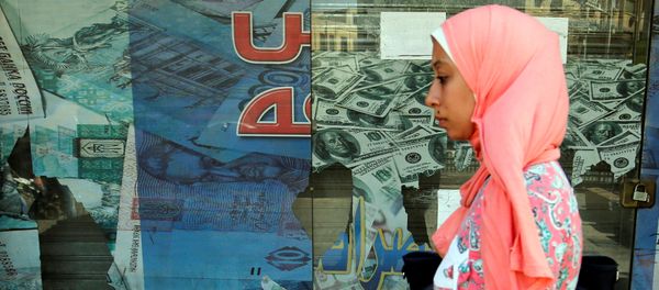 A woman walks past a money exchange bureau showing images of the U.S dollar with Egyptian pound and other foreign currency in Cairo, Egypt, October 12, 2016 A woman walks past a money exchange bureau showing images of the U.S dollar with Egyptian pound and other foreign currency in Cairo, Egypt, October 12, 2016 - Sputnik International