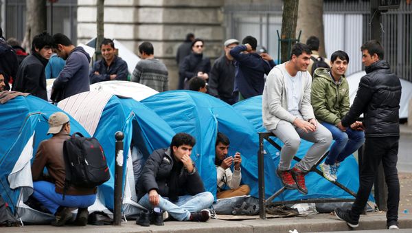 Migrants sit in their tents at a makeshift migrant camp on a street near the metro stations of Jaures and Stalingrad in Paris, France, October 28, 2016. Migrants sit in their tents at a makeshift migrant camp on a street near the metro stations of Jaures and Stalingrad in Paris, France, October 28, 2016. - Sputnik International