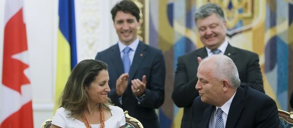 Canadian International Trade Minister Chrystia Freeland, foreground left, exchanges documents with First Vice Prime Minister, Minister of Economic Development and Trade of Ukraine Stepan Kubiv, foreground right, as Ukrainian President Petro Poroshenko, right, Canadian Prime Minister Justin Trudeau applaud during a signing ceremony in Kiev, Ukraine, Monday, July 11, 2016 - Sputnik International