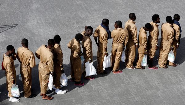 Migrants wait in line after disembarking from Spanish Navy cruiser Navarra in the Sicilian harbor of Catania, Italy, October 26, 2016. - Sputnik International