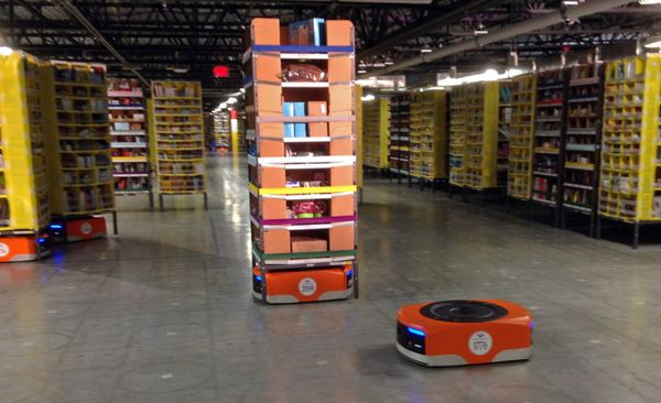 A Kiva robot drive unit is seen, foreground, before it moves under a stack of merchandise pods, seen on a tour of one of Amazon's newest distribution centers in Tracy, Calif. (File) - Sputnik International