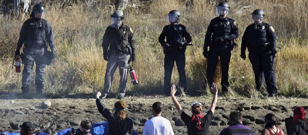 Dozens of protestors demonstrating against the expansion of the Dakota Access Pipeline wade in cold creek waters confronting local police, as remnants of pepper spray waft over the crowd near Cannon Ball, N.D., Wednesday, Nov. 2, 2016. Dozens of protestors demonstrating against the expansion of the Dakota Access Pipeline wade in cold creek waters confronting local police, as remnants of pepper spray waft over the crowd near Cannon Ball, N.D., Wednesday, Nov. 2, 2016. - Sputnik International