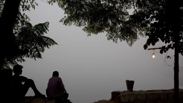 Indians sit on the banks of the river Yamuna engulfed with smog in New Delhi, India, Sunday, Nov. 6, 2016. - Sputnik International