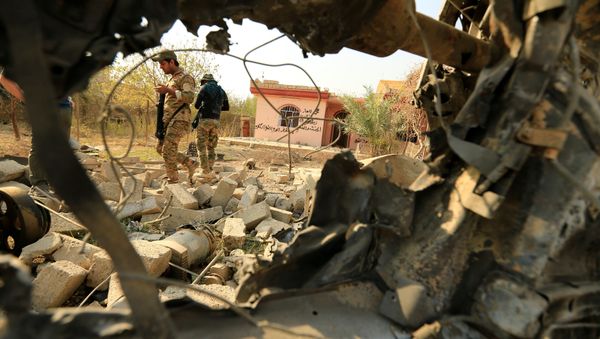 Iraqi security forces walk amidst rubble near a wreckage of a vehicle that was destroyed during clashes in Hammam al-Alil, south of Mosul, during an operation to attack Islamic State militants in Mosul, Iraq Iraqi security forces walk amidst rubble near a wreckage of a vehicle that was destroyed during clashes in Hammam al-Alil, south of Mosul, during an operation to attack Islamic State militants in Mosul, Iraq - Sputnik International