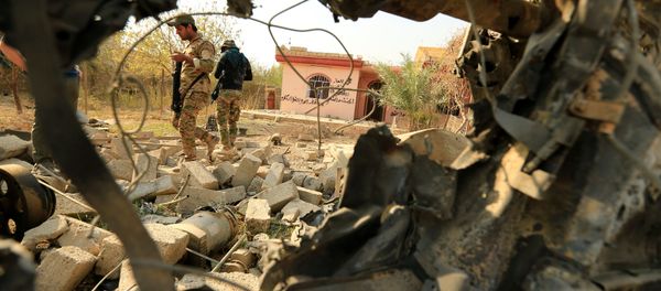 Iraqi security forces walk amidst rubble near a wreckage of a vehicle that was destroyed during clashes in Hammam al-Alil, south of Mosul, during an operation to attack Islamic State militants in Mosul, Iraq Iraqi security forces walk amidst rubble near a wreckage of a vehicle that was destroyed during clashes in Hammam al-Alil, south of Mosul, during an operation to attack Islamic State militants in Mosul, Iraq - Sputnik International