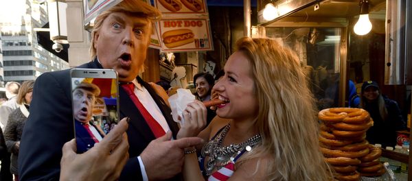 A Donald Trump impersonator with a bikini clad model stops at a hot dog vendor near Trump Tower on October 25, 2016 in New York, as part of a performance art piece by British artist Alison Jackson - Sputnik International