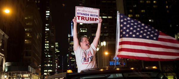 A supporter of U.S. Republican presidential candidate Donald Trump cheers near the intersection of West 54th Street and Fifth Avenue in New York, U.S. November 9, 2016 - Sputnik International