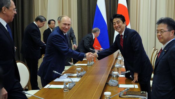 Russian President Vladimir Putin and Japanese Prime Minister Shinzo Abe shake hands at their meeting in the Bocharov Ruchei residence in Sochi, Russia, Saturday, Feb. 8, 2014.  - Sputnik International