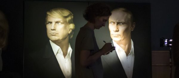 A journalist writes a material as she watches a live telecast of the U.S. presidential election standing at portraits of U.S. presidential candidate Donald Trump and Russian President Vladimir Putin in the Union Jack pub in Moscow, Russia, Wednesday, Nov. 9, 2016 - Sputnik International