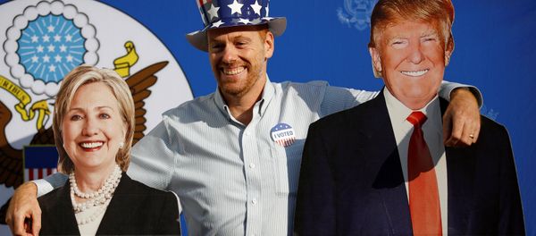 A man poses for a picture with the cardboard cutouts of US presidential nominees Hillary Clinton (L) and Donald Trump, at an election event hosted at the US ambassador's residence in Kathmandu, Nepal November 9, 2016. A man poses for a picture with the cardboard cutouts of US presidential nominees Hillary Clinton (L) and Donald Trump, at an election event hosted at the US ambassador's residence in Kathmandu, Nepal November 9, 2016. - Sputnik International