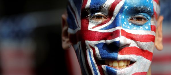 An activist with a face painted with the British Union Flag (L) and the US flag (R) poses in front of a Stop Trump battle bus in London on September 21, 2016 in a campaign run by campaign group Avaaz to mobilise US expatriots in the UK to register to vote in the US presidential election. Voters are set to go to the polls to elect the 45th president of the US on November 8, 2016. - Sputnik International