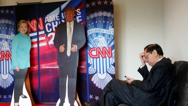A man checks his smartphone beside cardboard cutouts of U.S. presidential candidates Hillary Clinton (L) and Donald Trump, at an event held by the American Chamber of Commerce in Hong Kong, China November 9, 2016. A man checks his smartphone beside cardboard cutouts of U.S. presidential candidates Hillary Clinton (L) and Donald Trump, at an event held by the American Chamber of Commerce in Hong Kong, China November 9, 2016. - Sputnik International