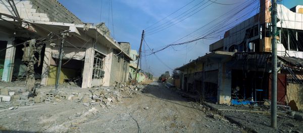 Damaged homes and shops due to clashes are seen through a glass window of a military vehicle in the town of Bashiqa, east of Mosul, Iraq, November 9, 2016 - Sputnik International