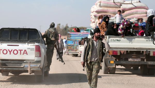 Syrian Democratic Forces (SDF) fighter walks near vehicles carrying people fleeing clashes in Tweila'a village and Haydarat area, north of Raqqa city, Syria November 8, 2016 Syrian Democratic Forces (SDF) fighter walks near vehicles carrying people fleeing clashes in Tweila'a village and Haydarat area, north of Raqqa city, Syria November 8, 2016 - Sputnik International
