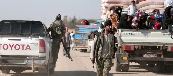 Syrian Democratic Forces (SDF) fighter walks near vehicles carrying people fleeing clashes in Tweila'a village and Haydarat area, north of Raqqa city, Syria November 8, 2016 - Sputnik International