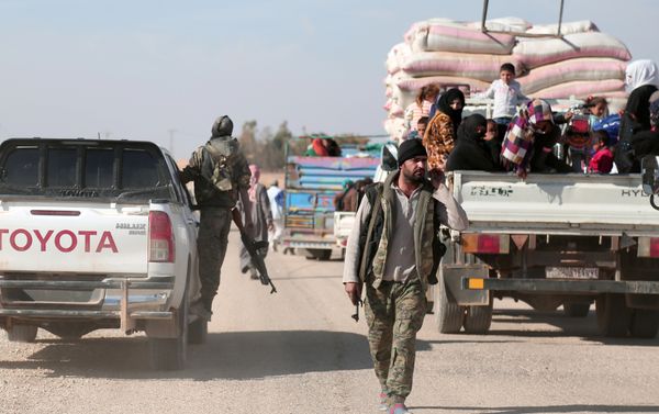 Syrian Democratic Forces (SDF) fighter walks near vehicles carrying people fleeing clashes in Tweila'a village and Haydarat area, north of Raqqa city, Syria November 8, 2016 - Sputnik International