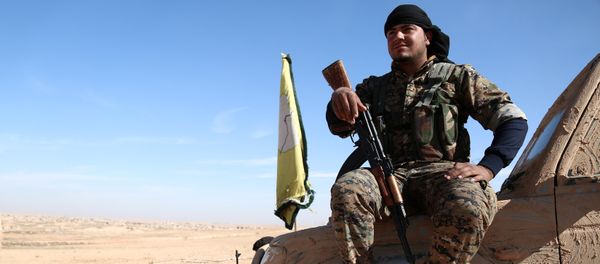 A Syrian Democratic Forces (SDF) fighter rests with his weapon on a vehicle camouflaged with mud, north of Raqqa city, Syria November 7, 2016 - Sputnik International