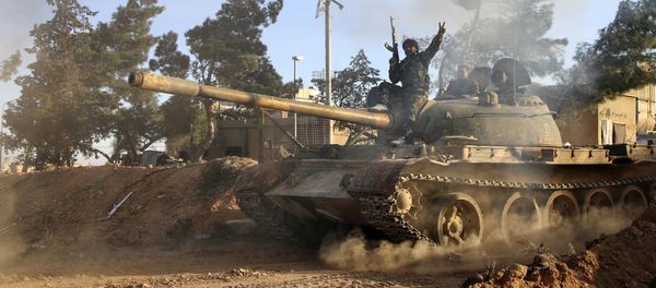 Volunteer fighter with the Syrian Government forces sits atop a tank in the province of Raqqa, Syria (File) - Sputnik International