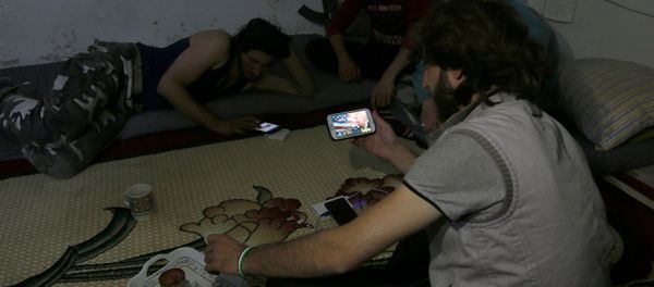 A Harakat Nour al-Din al-Zenki fighter watches news about Donald Trump's election as president on his smart phone in the rebel held beseiged area in Aleppo, Syria November 9, 2016 - Sputnik International