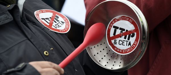 A demonstrator holds a lid with a sticker reading TTIP & CETA crossed during a protest against the EU-Canada Comprehensive Economic and Trade Agreement (CETA) at European Union Commission headquarters in Brussels on October 27, 2016. A demonstrator holds a lid with a sticker reading TTIP & CETA crossed during a protest against the EU-Canada Comprehensive Economic and Trade Agreement (CETA) at European Union Commission headquarters in Brussels on October 27, 2016. - Sputnik International